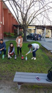 Students preparing to drop Mentos into various sodas, with gushing results.