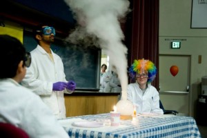 people watching a smoking chemical reaction