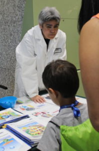 Chemist stands at table with child