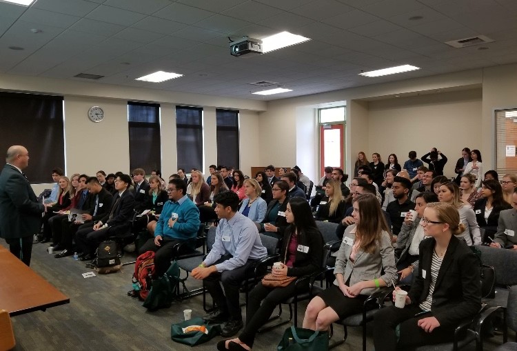 crowd of people sitting in chairs in a room