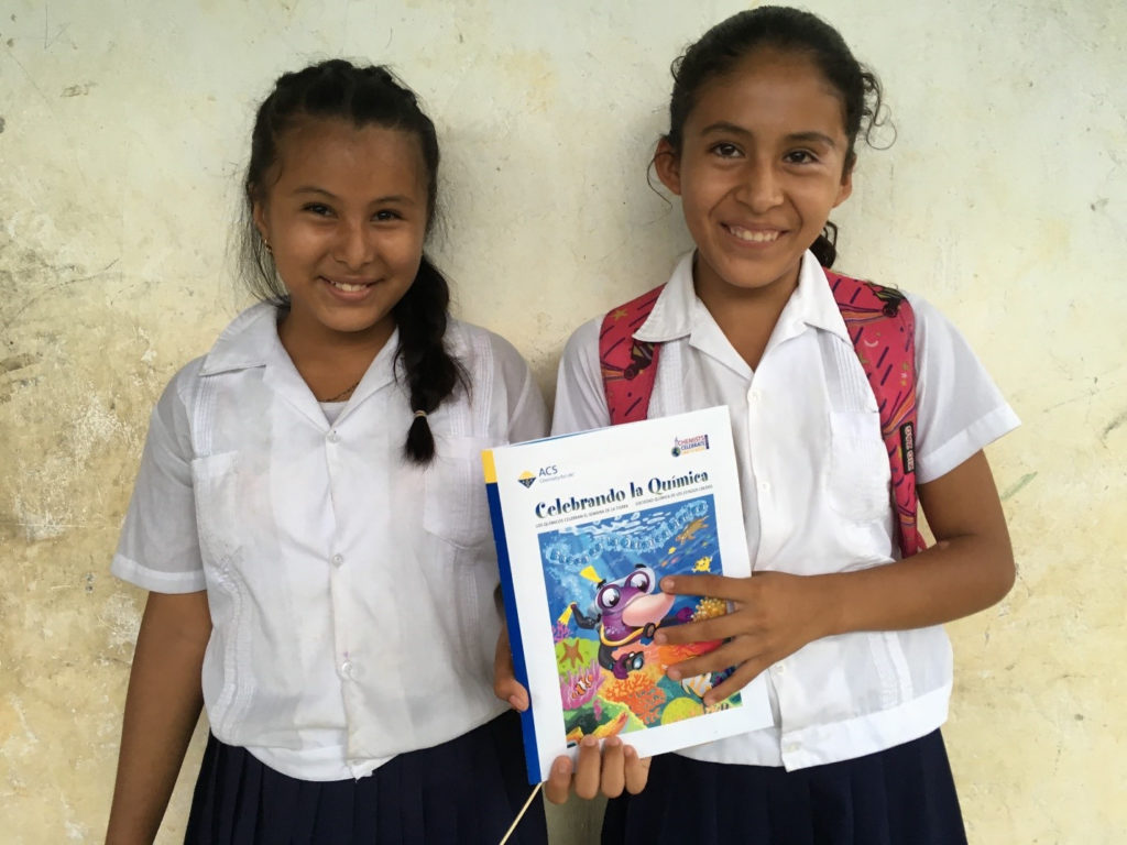 two girls holding a pamphlet